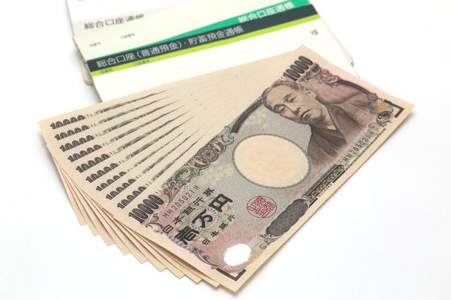 複数の一万円札と通帳